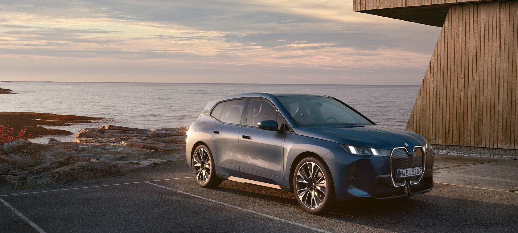 BMW iX in grau-blau vor dem Meer - Angebot für Großkunden bei der Wahl-Group