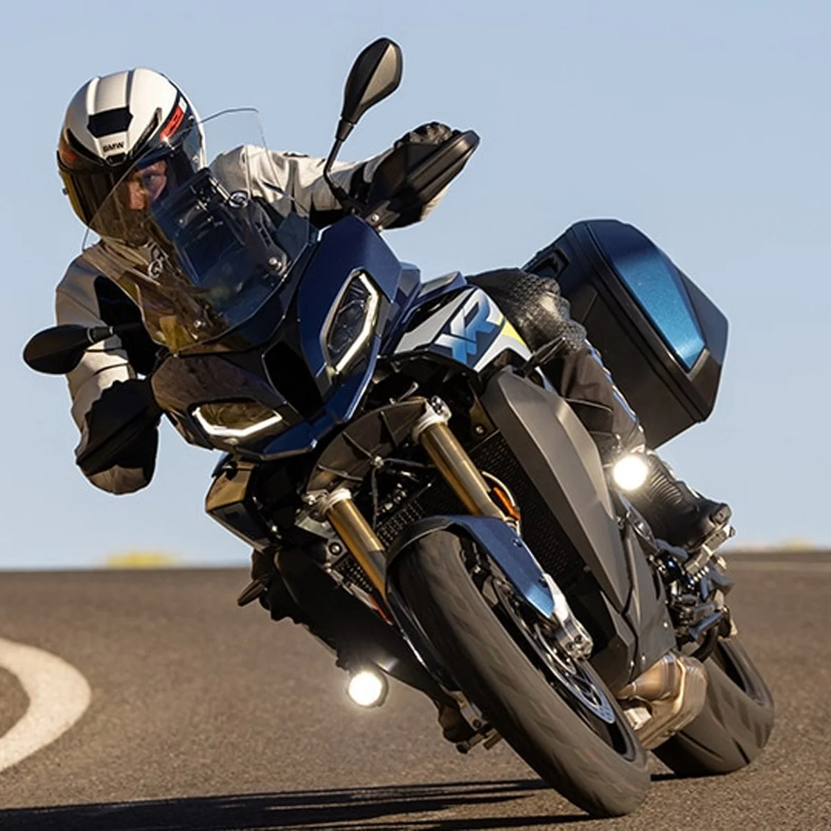 BMW Motorrad mit Nano Zusatzscheinwerfern – maximale Sicht bei jeder Kurve | Wahl-Group BMW Motorrad in Kurvenfahrt mit aktivierten Nano Zusatzscheinwerfern bei Tageslicht auf kurviger Landstraße