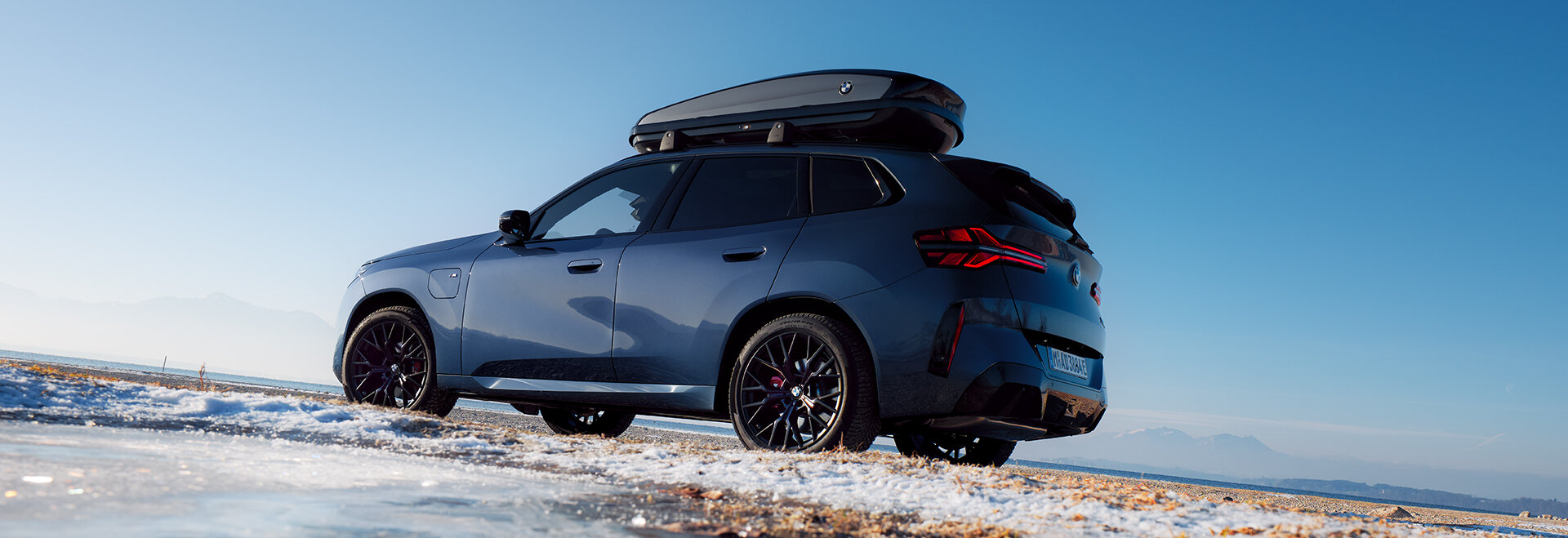 BMW X3 G45 mit Winterkompletträder | Angebote für Original Winterkompletträder Blauer BMW X3 30e xDrive Plug-in-Hybrid mit originalen BMW Winterkompletträdern auf einer vereisten Straße – Angebote für BMW Winterkompletträder.