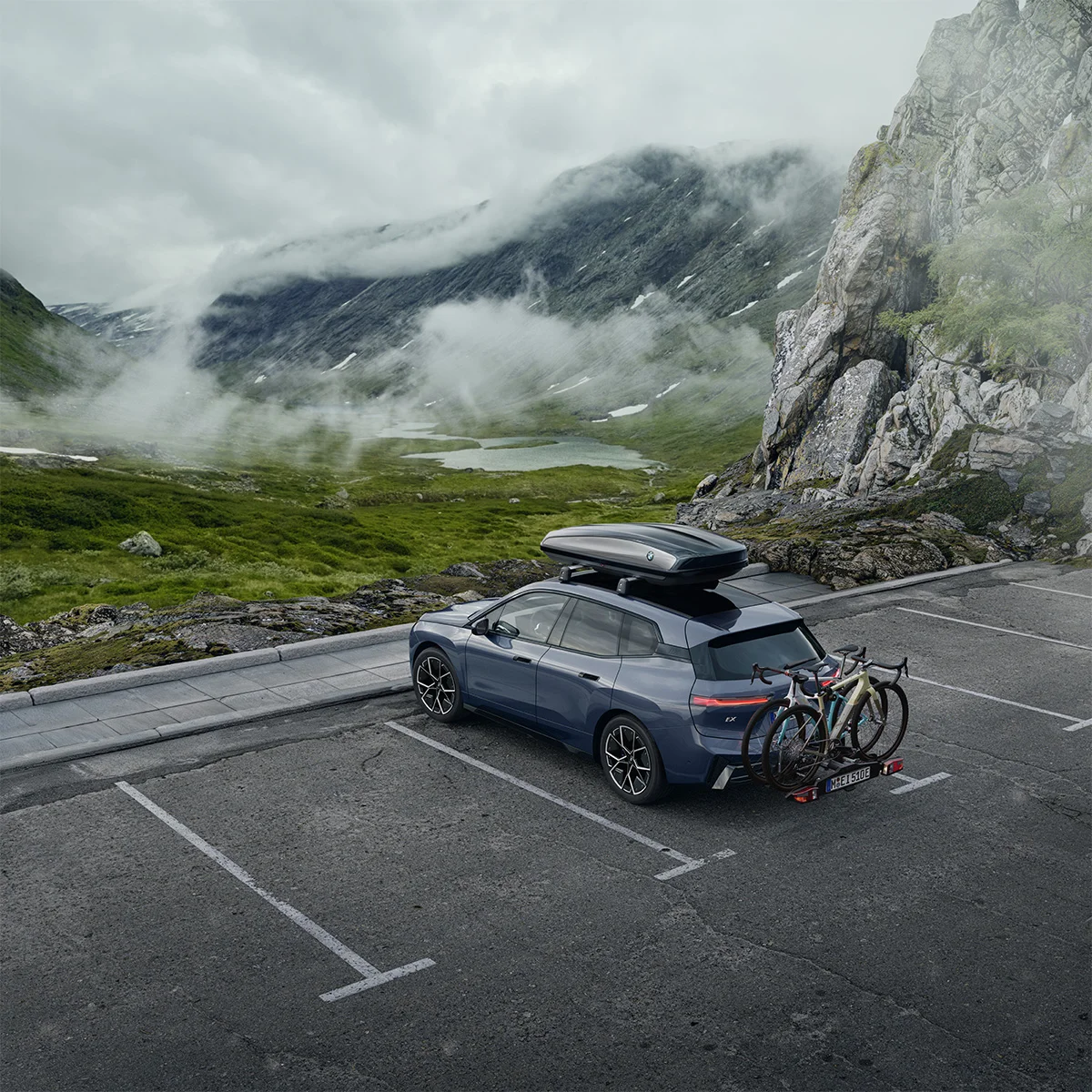 BMW iX mit Fahrradträger und Dachbox in alpiner Landschaft – Zubehör von der Wahl-Group