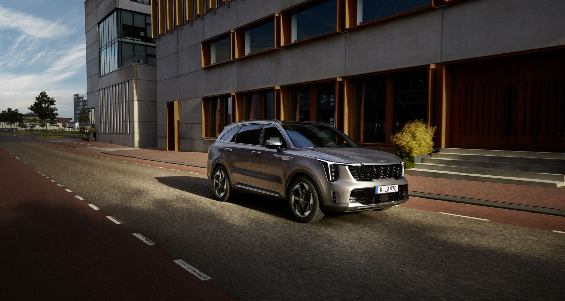 Kia Sorento in Bewegung – Dynamische Front-Seitenansicht des SUVs auf der Straße Fahrender Kia Sorento aus Front-/Seitenansicht – kraftvoller Auftritt mit markantem Design und sportlicher Präsenz