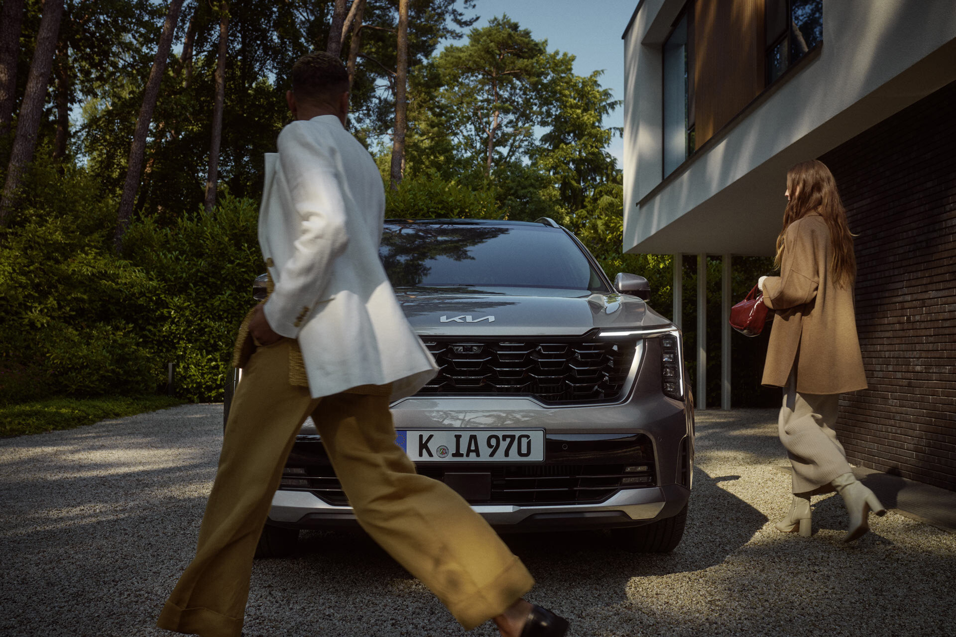 Kia Sorento – Markante Front trifft auf Lifestyle-Moment mit zwei Frauen im Fokus Kia Sorento von vorn mit zwei Frauen im Vordergrund – moderner SUV als stilvoller Begleiter im Alltag