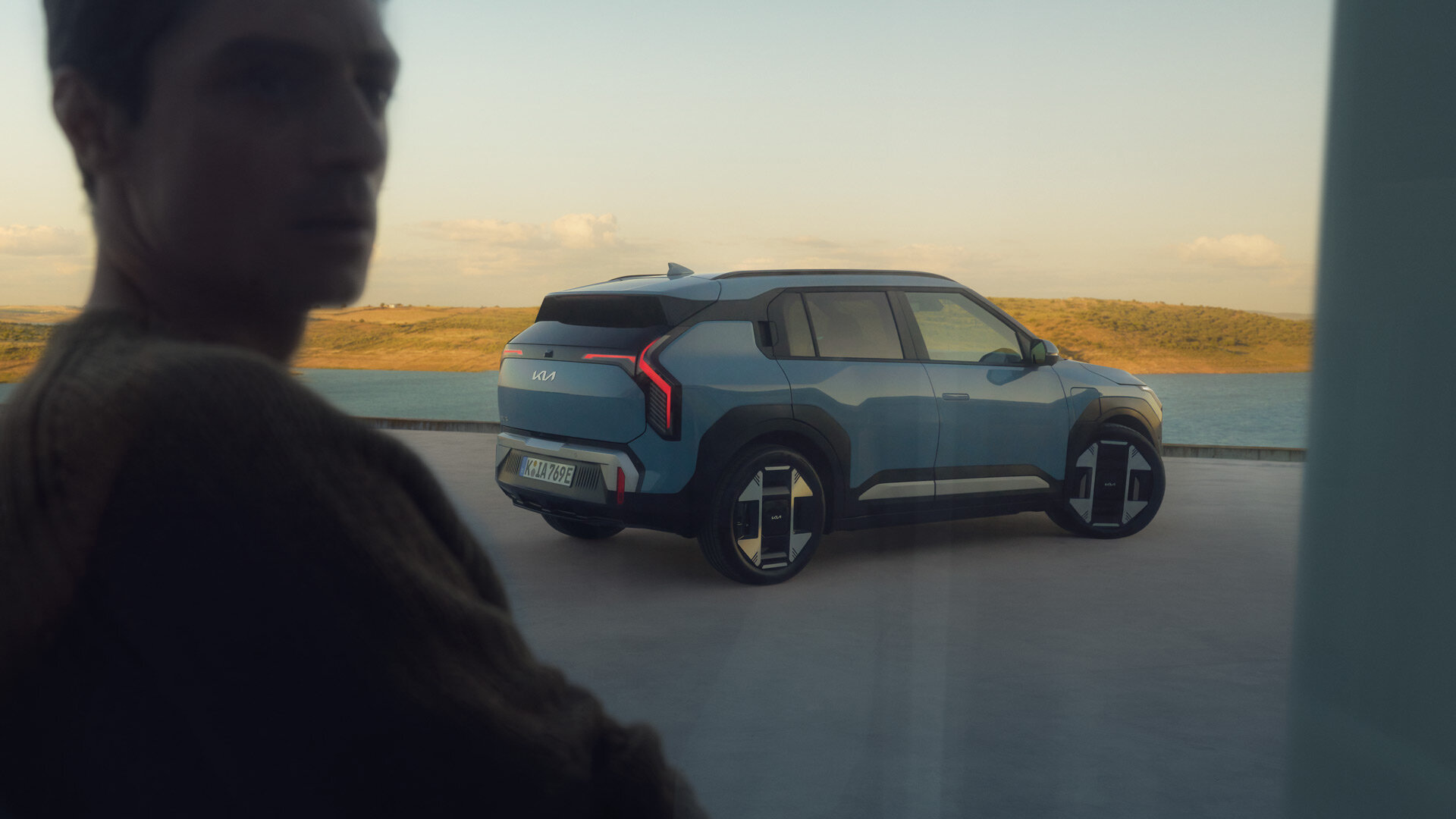 Kia EV3 - Dynamische Heckansicht - Innovatives Crossover-Design Kia EV3 Heckansicht mit LED-Leuchtenband und charakteristischer Silhouette im Sonnenuntergang