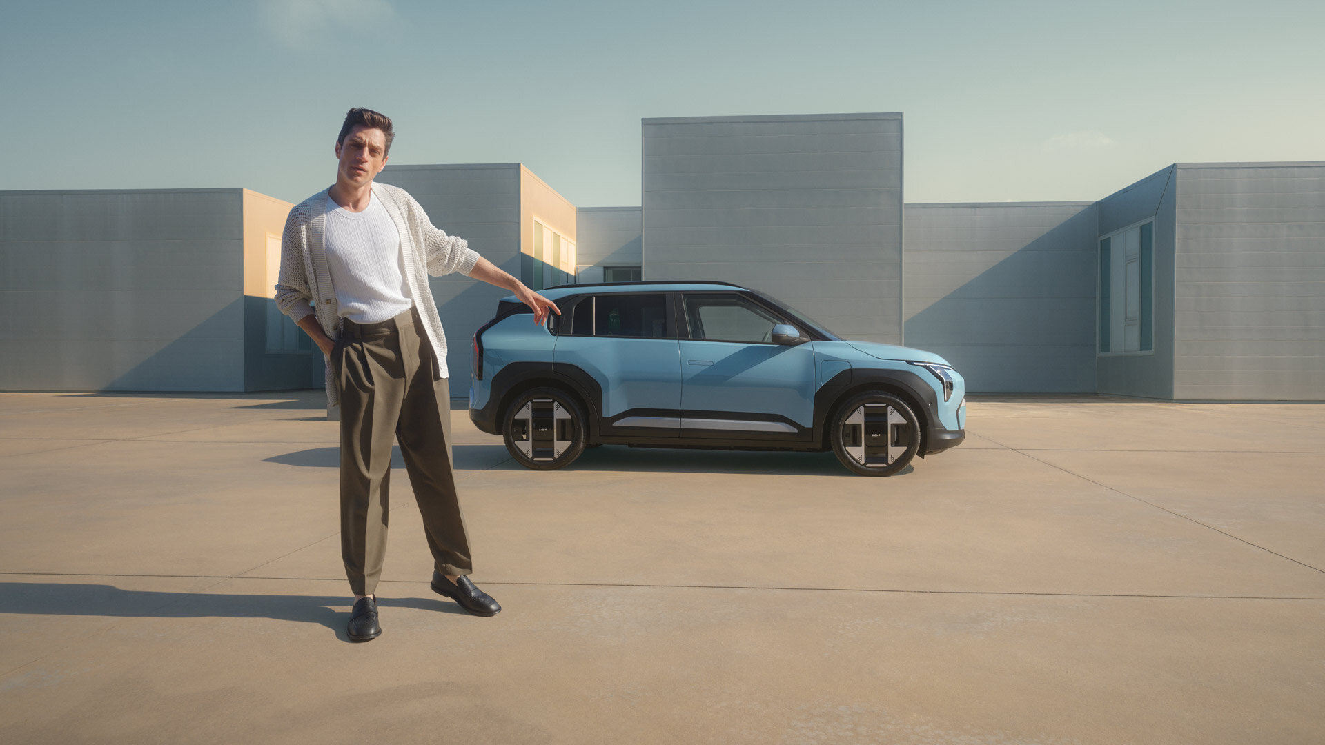 Kia EV3 - Kompakter Elektro-Crossover - Design trifft Nachhaltigkeit Kia EV3 Elektro-Crossover in hellblau mit moderner Architektur im Hintergrund und minimalistischem Lifestyle-Design