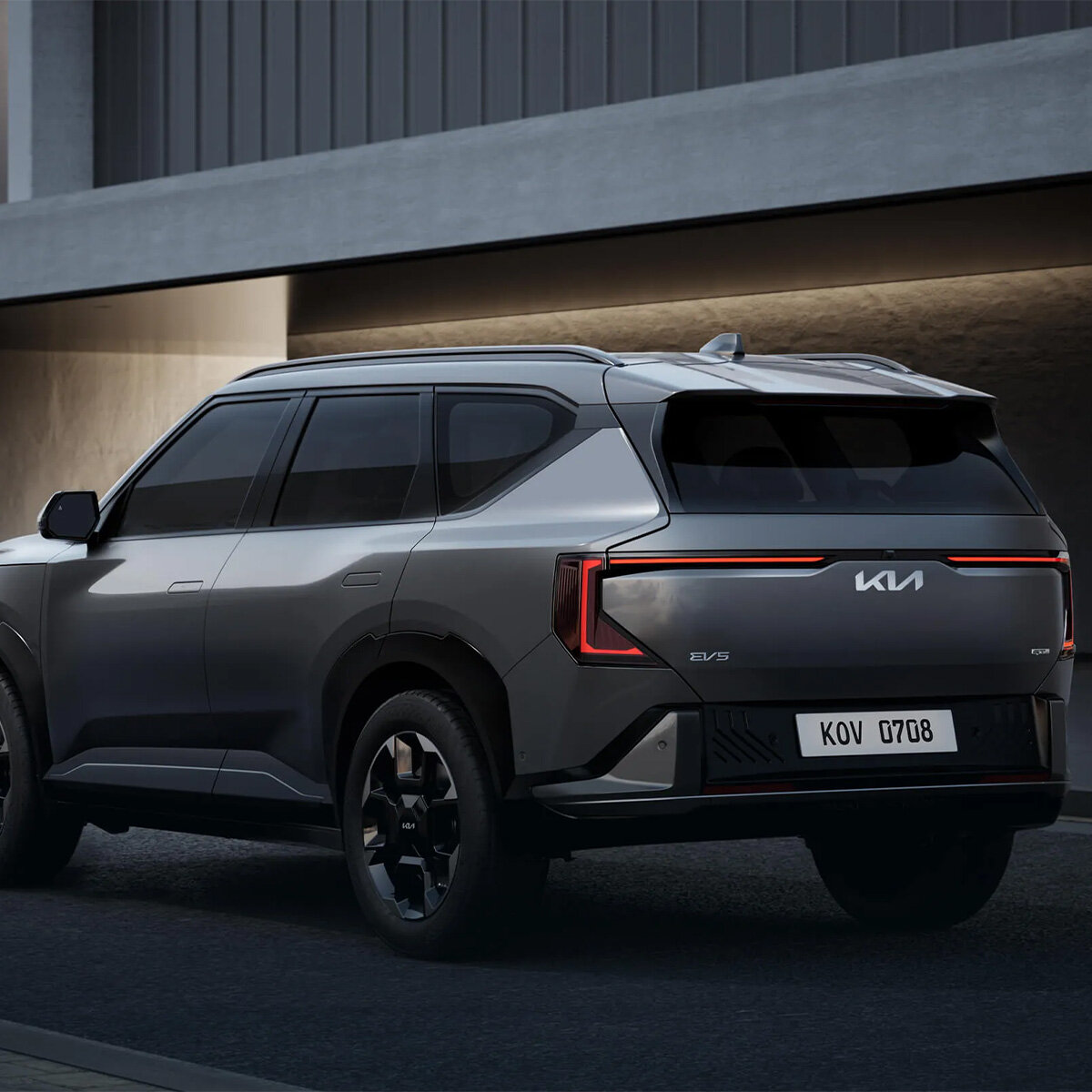 Dynamische schräg hintere Ansicht des Kia EV5 Elektro-SUV in Grau auf der Straße bei der Wahl-Group