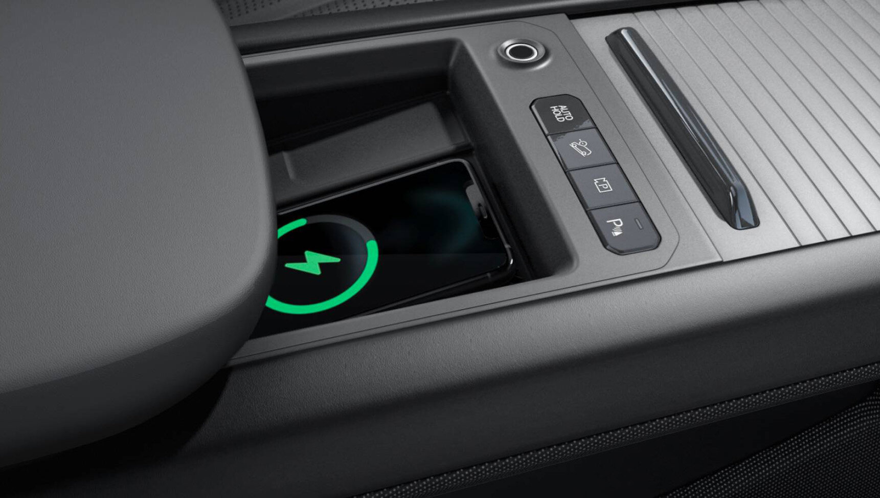 Kia EV9 mit integrierter induktiver Ladestation in der Mittelkonsole für bequemes und sicheres kabelloses Laden von Smartphones.