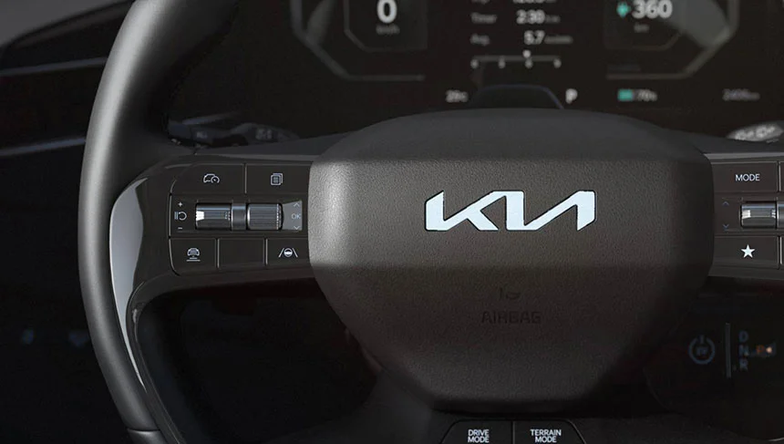 Kia EV9 Lenkrad mit beleuchtetem Kia-Emblem und intuitiven Bedienelementen für maximalen Fahrkomfort.