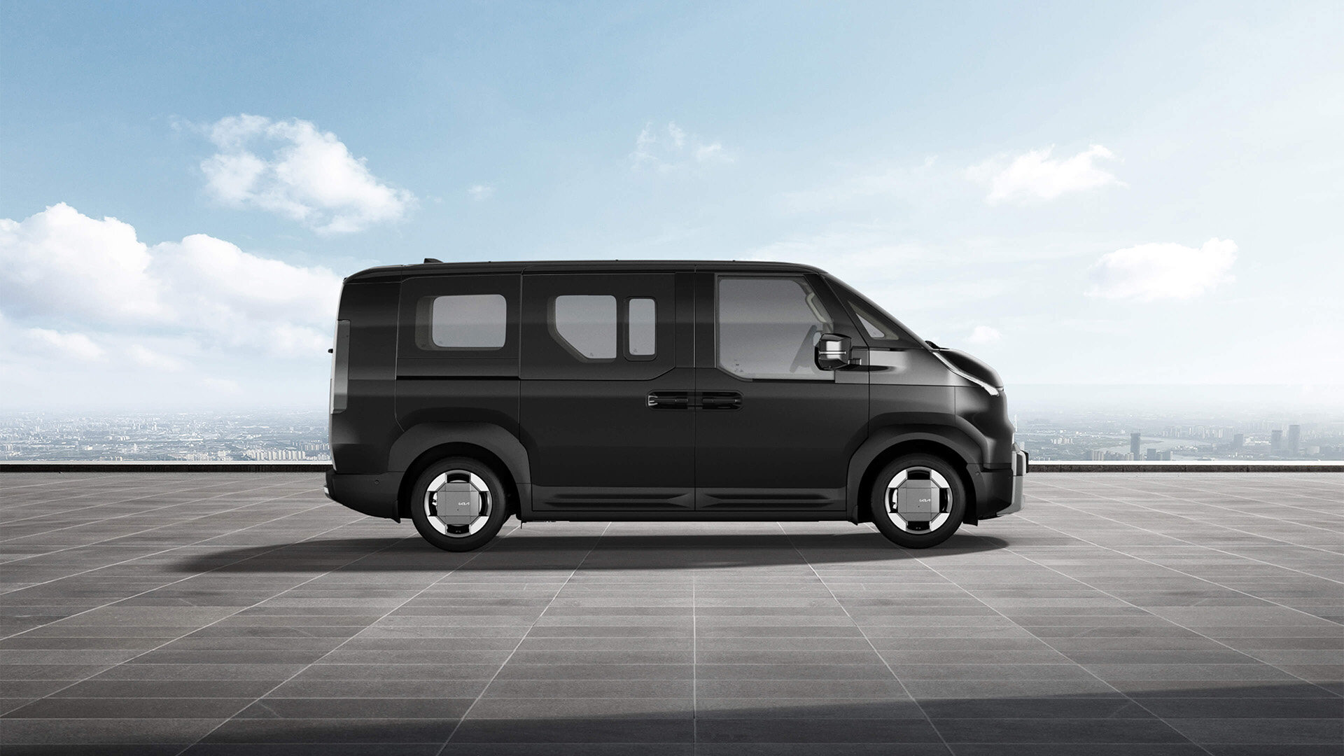 Ein Kia PV5 Passenger in der eleganten Farbe Aurora Schwarz Pearl, präsentiert in einer stilvollen Urbanen Umgebung.