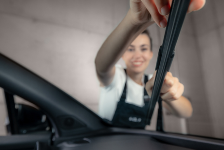 Servicemitarbeiterin setzt ein neues Wischerblatt an einem Kia ein